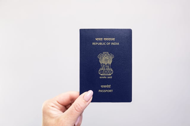 A hand holding an Indian Passport