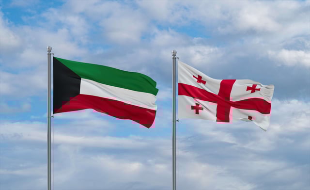 Georgia And Kuwait Flags Waving Together On Blue Cloudy Sky