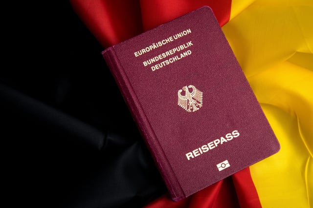 German Passport On Flag Of Federal Republic Of Germany