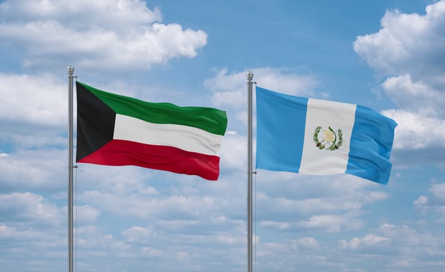 Guatemala And Kuwait Flags Waving Together On Blue Cloudy Sky