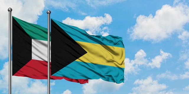 Kuwait And Bahamas Flag Waving In The Wind Against White Cloudy Blue Sky Together