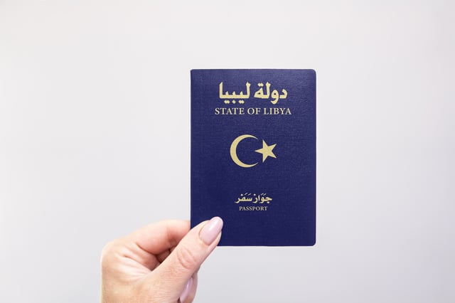 Libya Passport Held In Hand Against A Plain