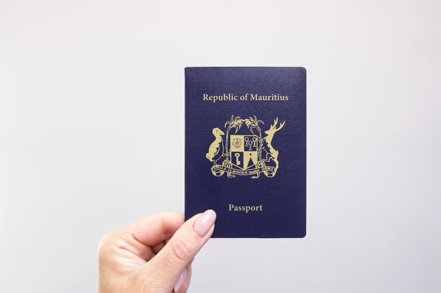 Mauritius Passport Held In Hand Against A Plain