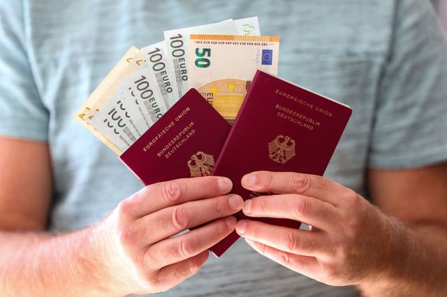Two New German Passports And Vacation Money In The Hands Of A Man