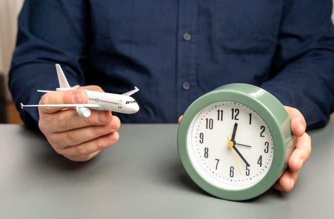 A man holding a plane and a clock