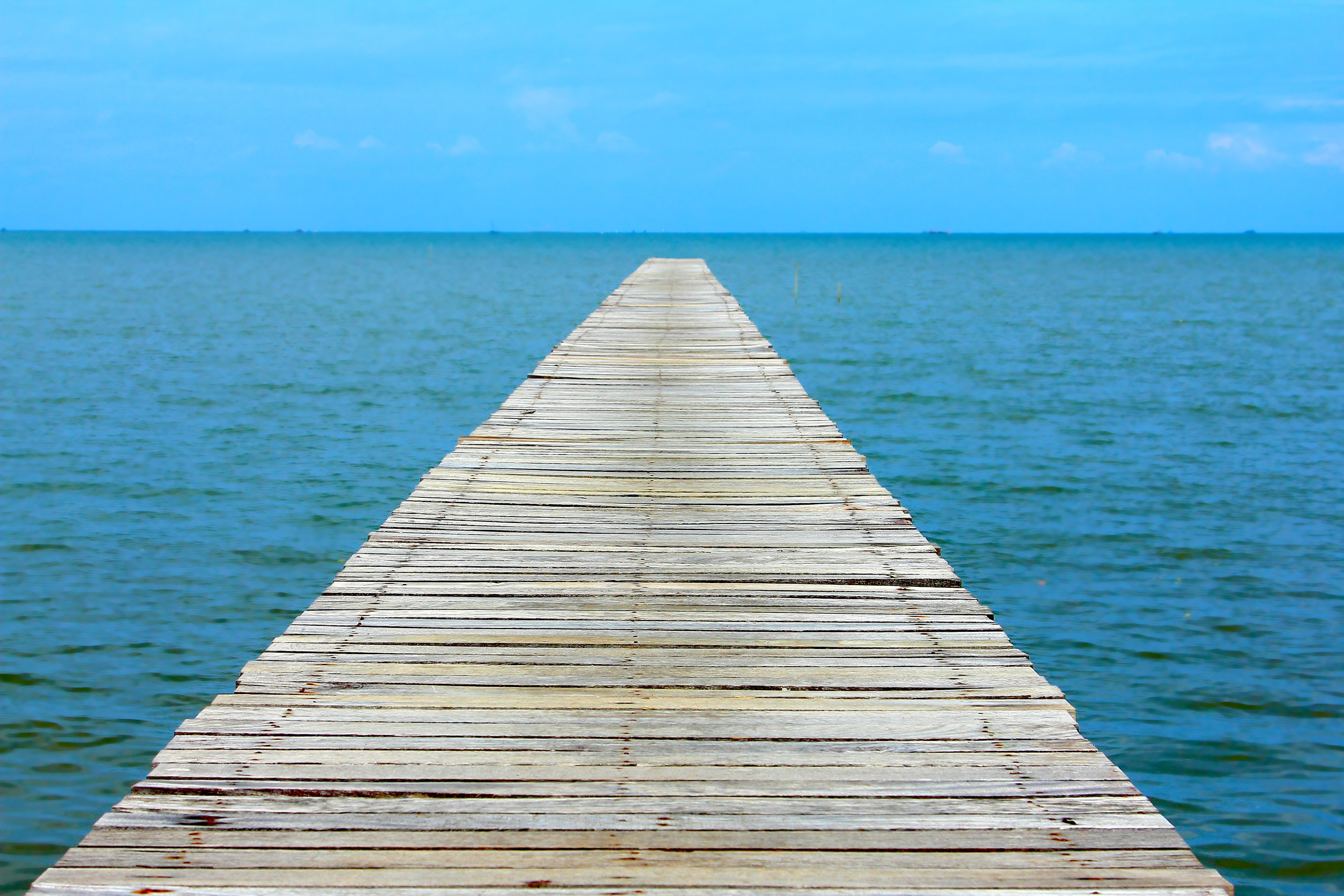 blue sky clear with wooden bridge extending into the sea at resort on holiday relax