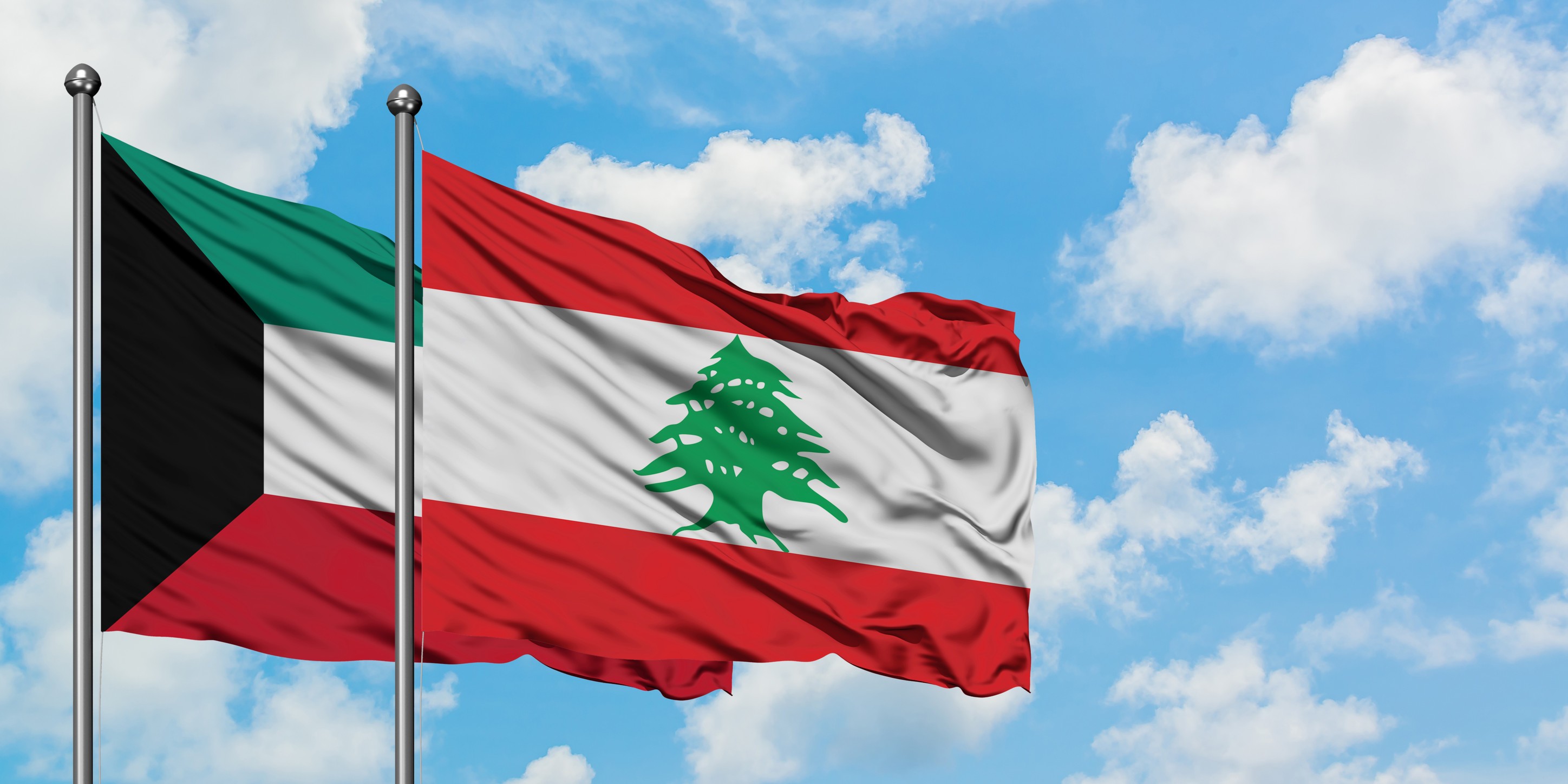 Kuwait And Lebanon Flag Waving In The Wind Against White