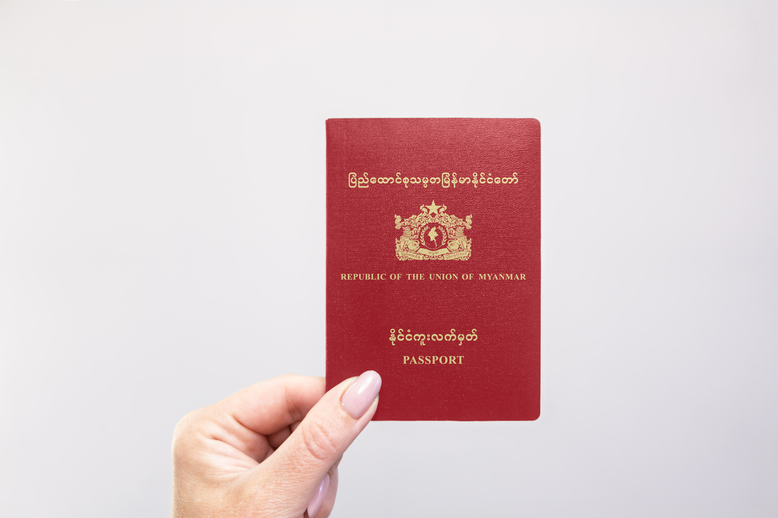 Myanmar Passport Held In Hand Against A Plain